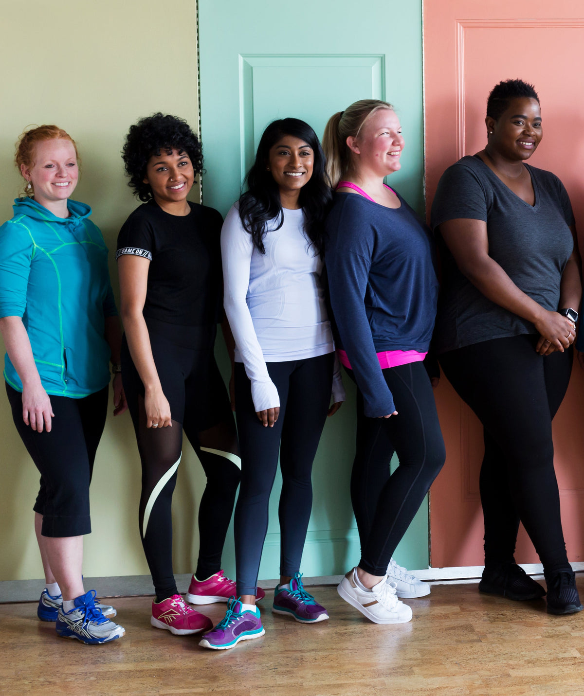 A group of women in fitness clothing all looking happy and cheerful