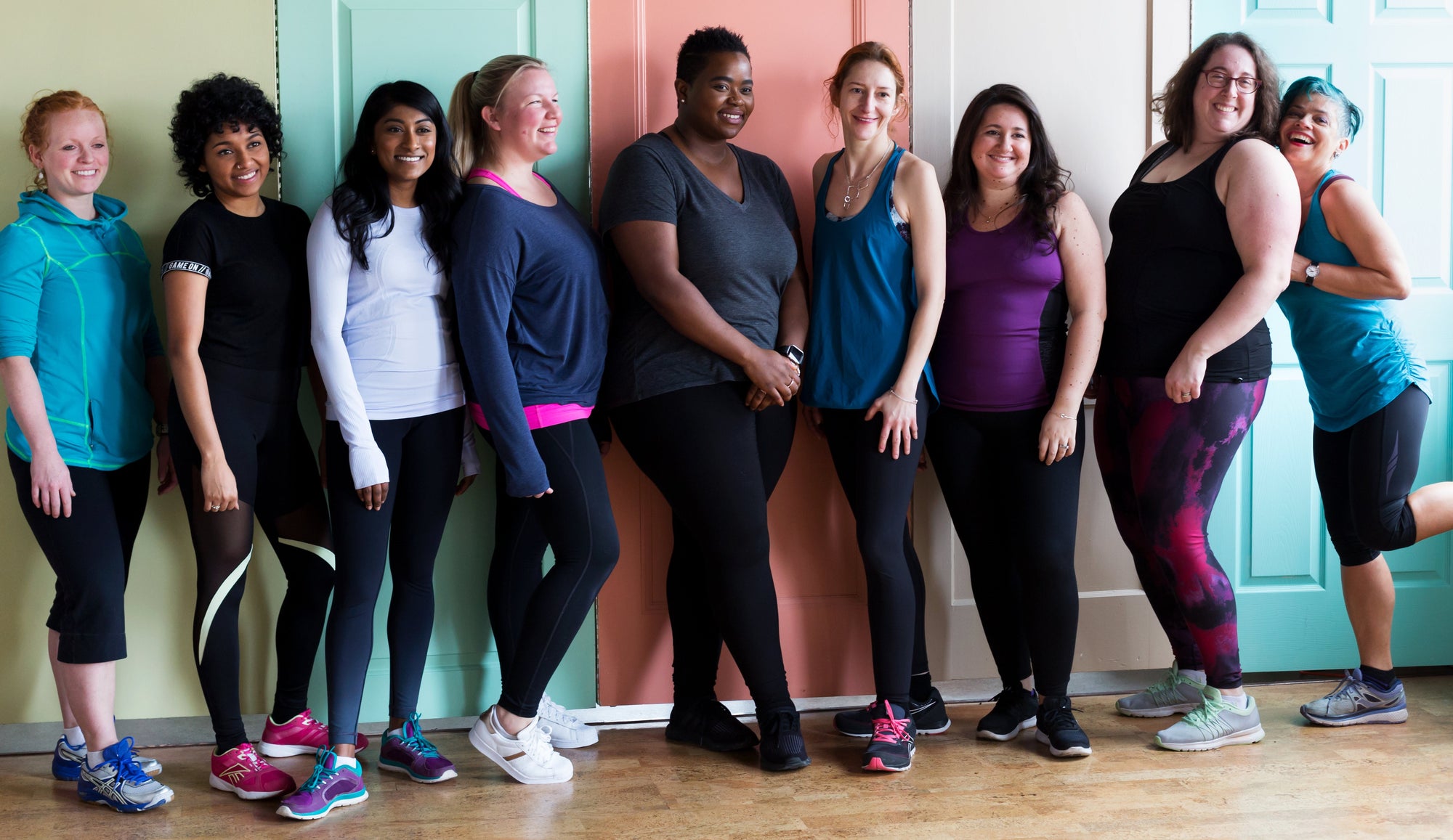 A group of women in fitness clothing all looking happy and cheerful